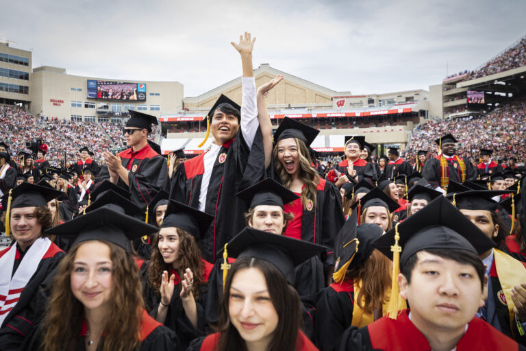 Students cheering at graduation in Camp Randall stadium